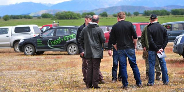 image of farmers at field day infront of cars