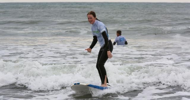 image of girl surfing in branded B+LNZ top